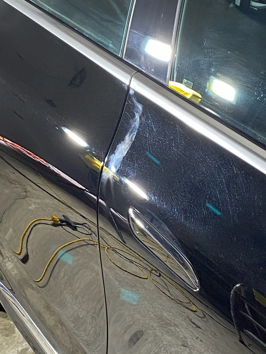 Before: scratches and swirls on a black door